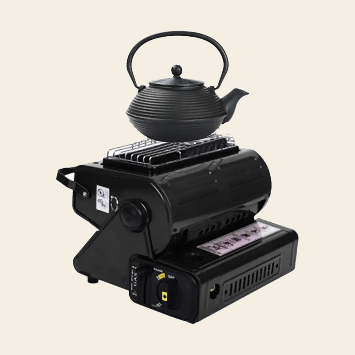 Portable butane gas heater and camp stove in black with a cast iron kettle sitting on its cooking ring